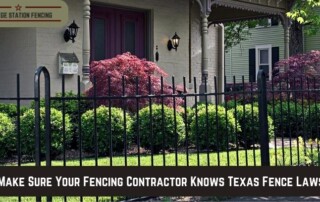 A black metal fence in front of a house with shrubs and a banner stating, Make sure your fencing contractor knows Texas fence laws!.